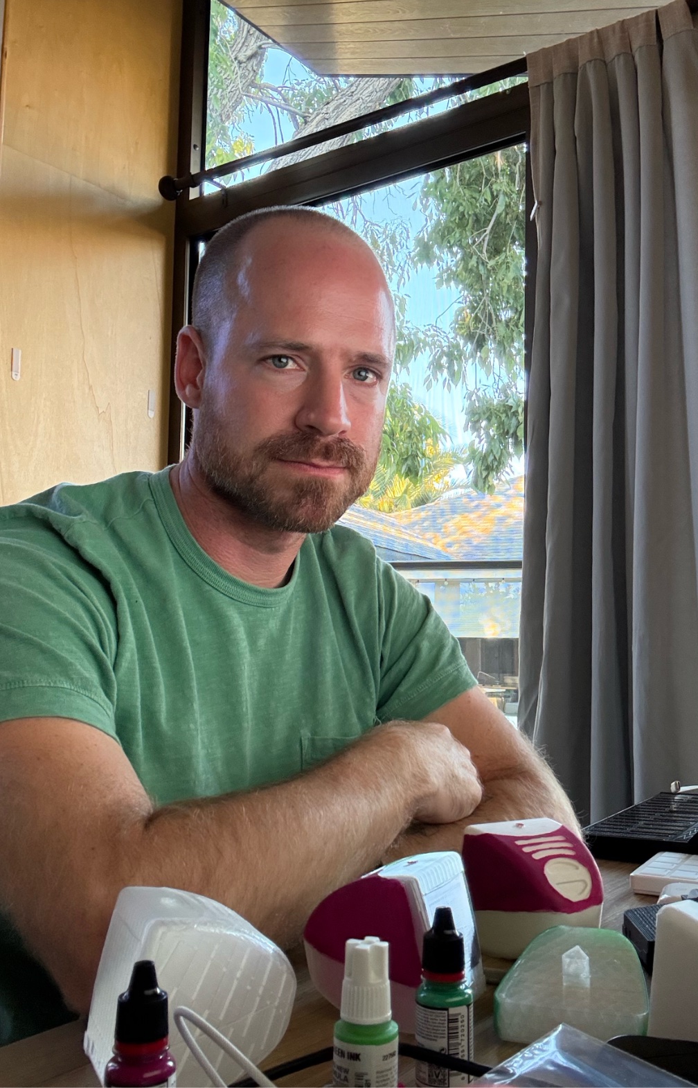 Brian King sitting near a window with small creative tools in the foreground