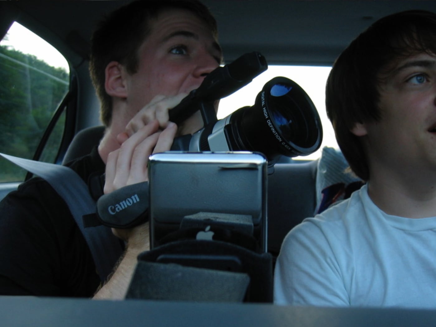 Two people in a car with a Canon camcorder during an early video shoot
